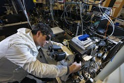 Postdoctoral researcher Xiao Qi in the laser room at the Molecular Foundry, with the team’s optical setup for photon avalanching nanoparticles (in which a small increase in laser power causes a giant increase in the amount of light they emit).